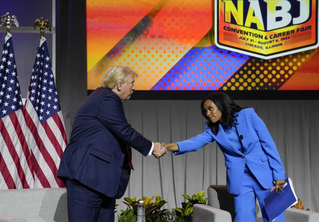 Former President Donald Trump shakes hands with ABC's Rachel Scott, one of the journalists who moderated the event at NABJ in Chicago on Wednesday.