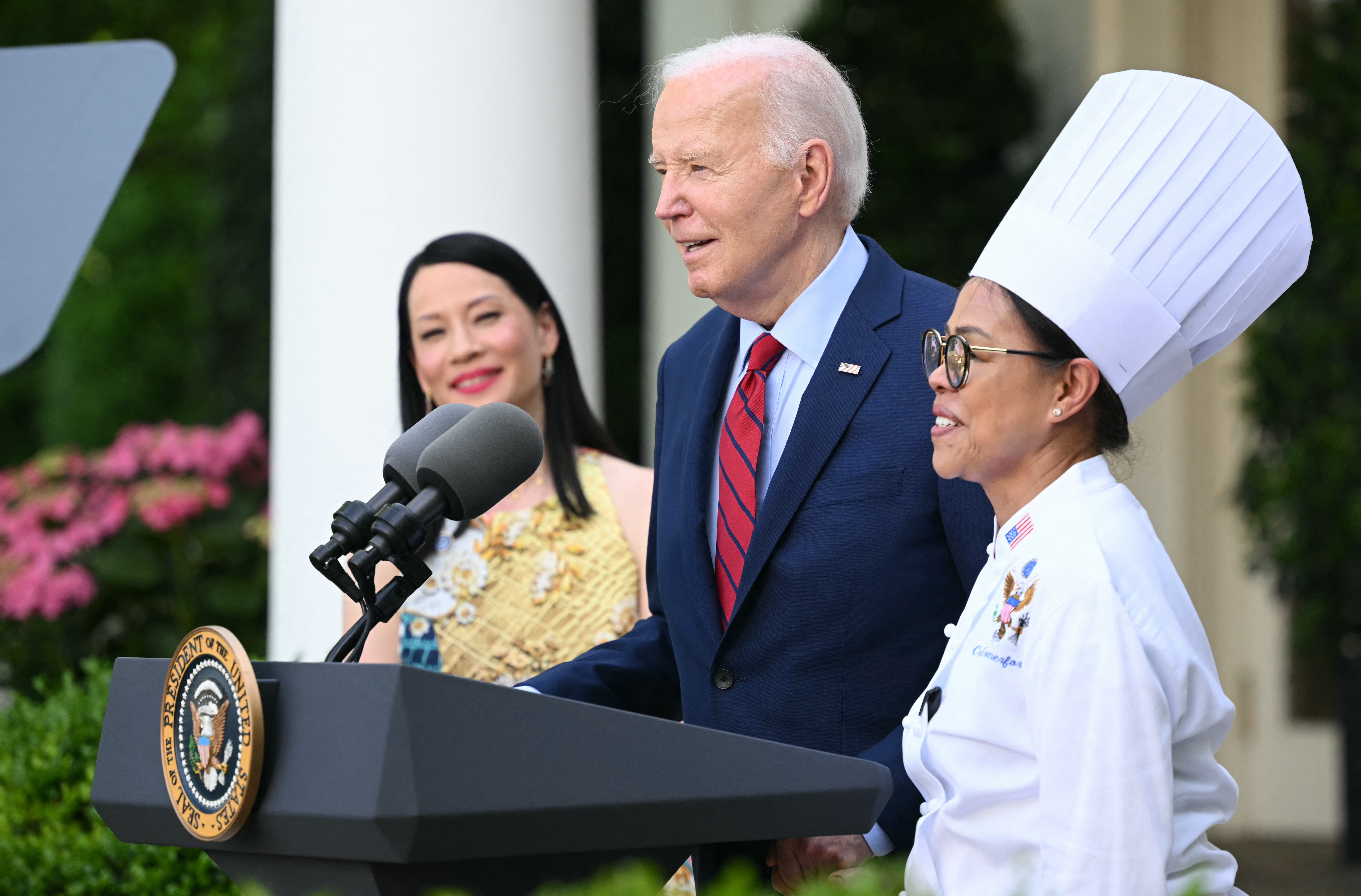 President Biden welcomes then White House executive chef Cristeta Comerford to the podium during a reception celebrating Asian American, Native Hawaiian and Pacific Islander Heritage Month in May.