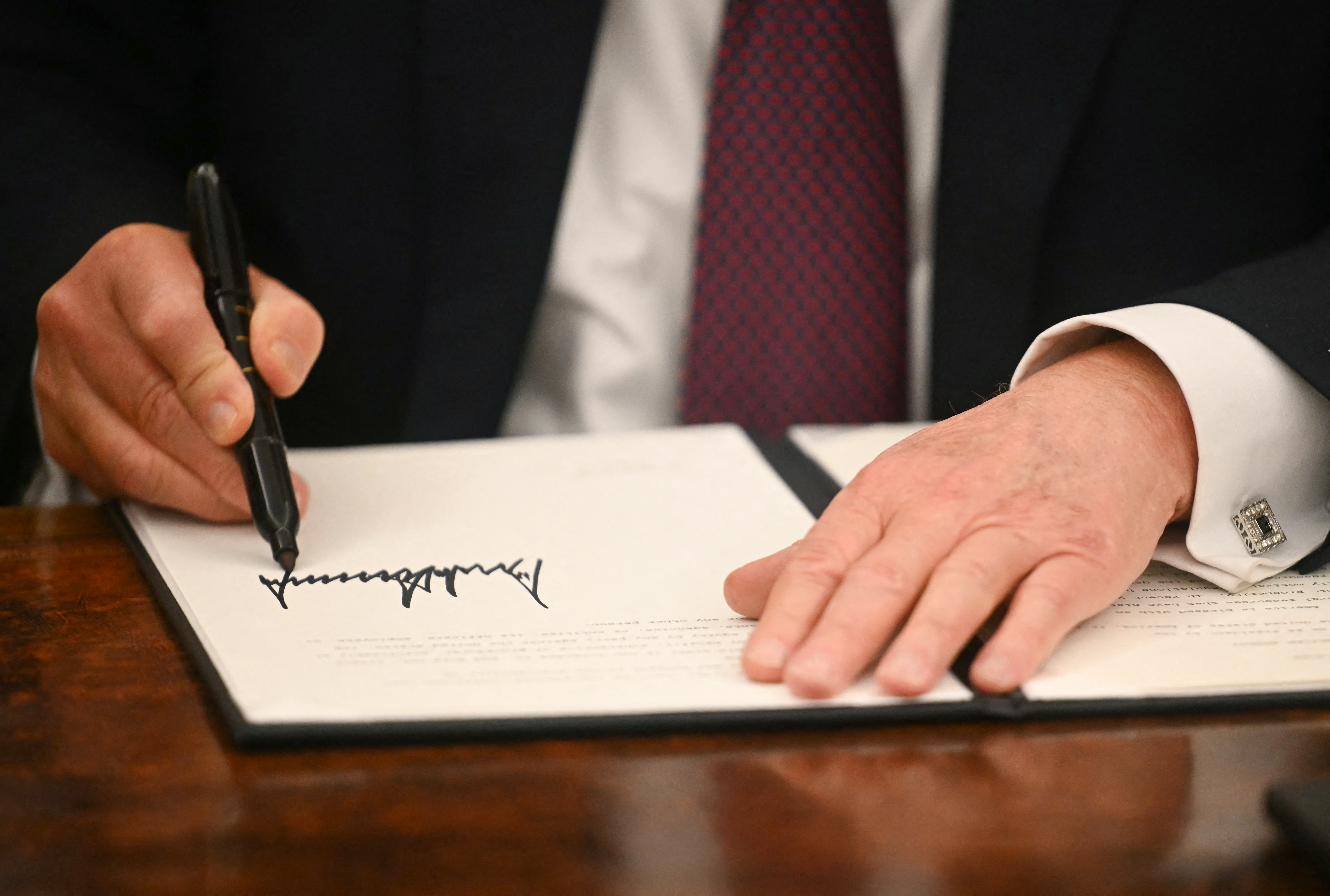 President Trump signs an executive order in the Oval Office of the White House on Jan. 20. Trump has used executive orders to establish multiple national emergencies, which give him access to expanded powers.