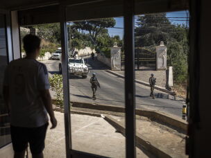 A young Christian observes a Spanish UNIFIL battalion patrolling the streets of the Christian village of Ibel al-Saqi. UNIFIL has resumed street patrols <em>following</em> the escalation of hostilities in March 2026, which has killed more than 4,354 people across Lebanon, according to the Lebanese Health Ministry