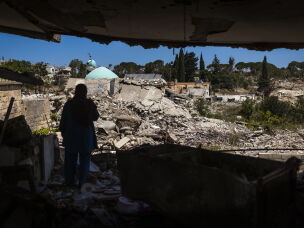 Mahasen Fakih stands outside her destroyed apartment in Zawtar al-Gharbiyah after returning to the village days earlier. The village is the first in a pilot project brokered by the U.S. for Israeli forces to withdraw and Lebanese forces to move in to secure the area.