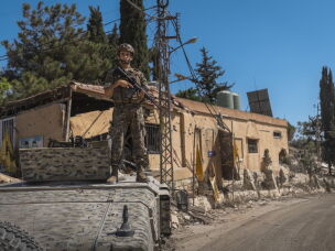 A Lebanese Armed Forces (LAF) soldier stands outside an armored vehicle at the