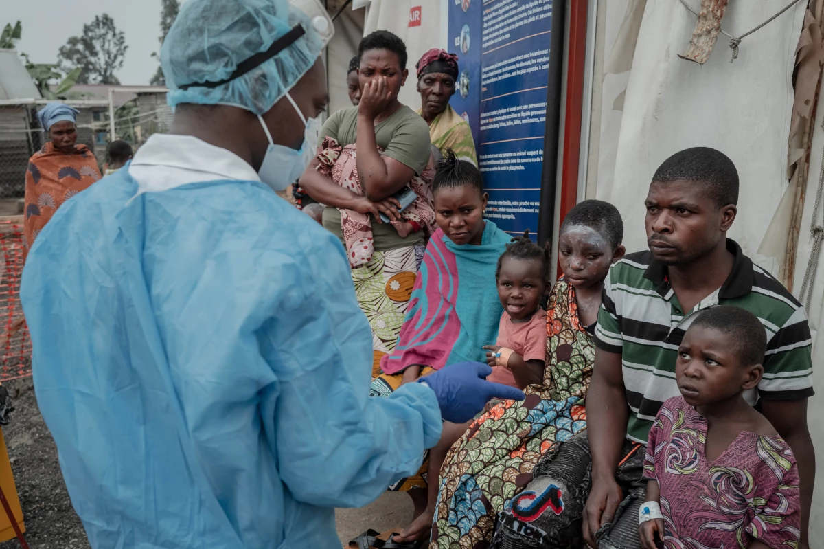 TOPSHOT - Patients listen to a doctor outside the consultation room of the Mpox treatment centre at Nyiragongo General Referral Hospital, north of Goma on August 17, 2024. With around 16,000 cases recorded since the beginning of the year, the DRC is the focus and epicentre of the epidemic that led the World Health Organisation (WHO) to trigger its highest level of alert at the international level on Wednesday. The province of South Kivu records around 350 new cases per week, according to Dr Justin Bengehya, epidemiologist at the provincial health division of South Kivu. Goma, capital of the province of North Kivu, almost surrounded by an armed rebellion and where hundreds of thousands of displaced people are crammed into makeshift camps, fears a large-scale spread due to promiscuity. (Photo by GUERCHOM NDEBO / AFP) (Photo by GUERCHOM NDEBO/AFP via Getty Images)
