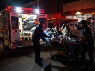 Paramedics load an injured person into an ambulance at the Wainwright Health center after a fire at Canadian Forces Base Wainwright, outside of Wainwright, Alberta Saturday, Oct. 17, 2026.