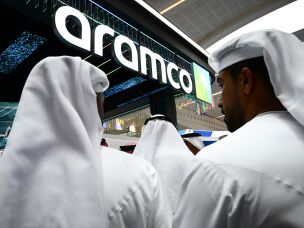 Guests stand at the booth of Saudi Arabia's Aramco oil company during the Abu Dhabi International Petroleum Exhibition & Conference, in Abu Dhabi, United Arab Emirates, on Nov. 3, 2025.