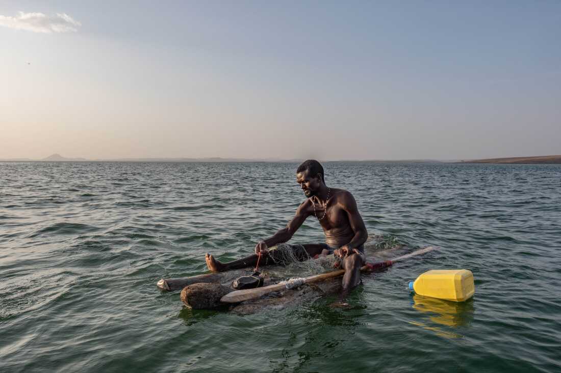 James Lekubo, a 36 year old El Molo fisherman from Komote Island in lake Turkana, pulls in his nets while fishing from a traditional raft made of palm trunks. Like others throughout the lake, Lekubo says his catches have dwindled hugely in recent years.