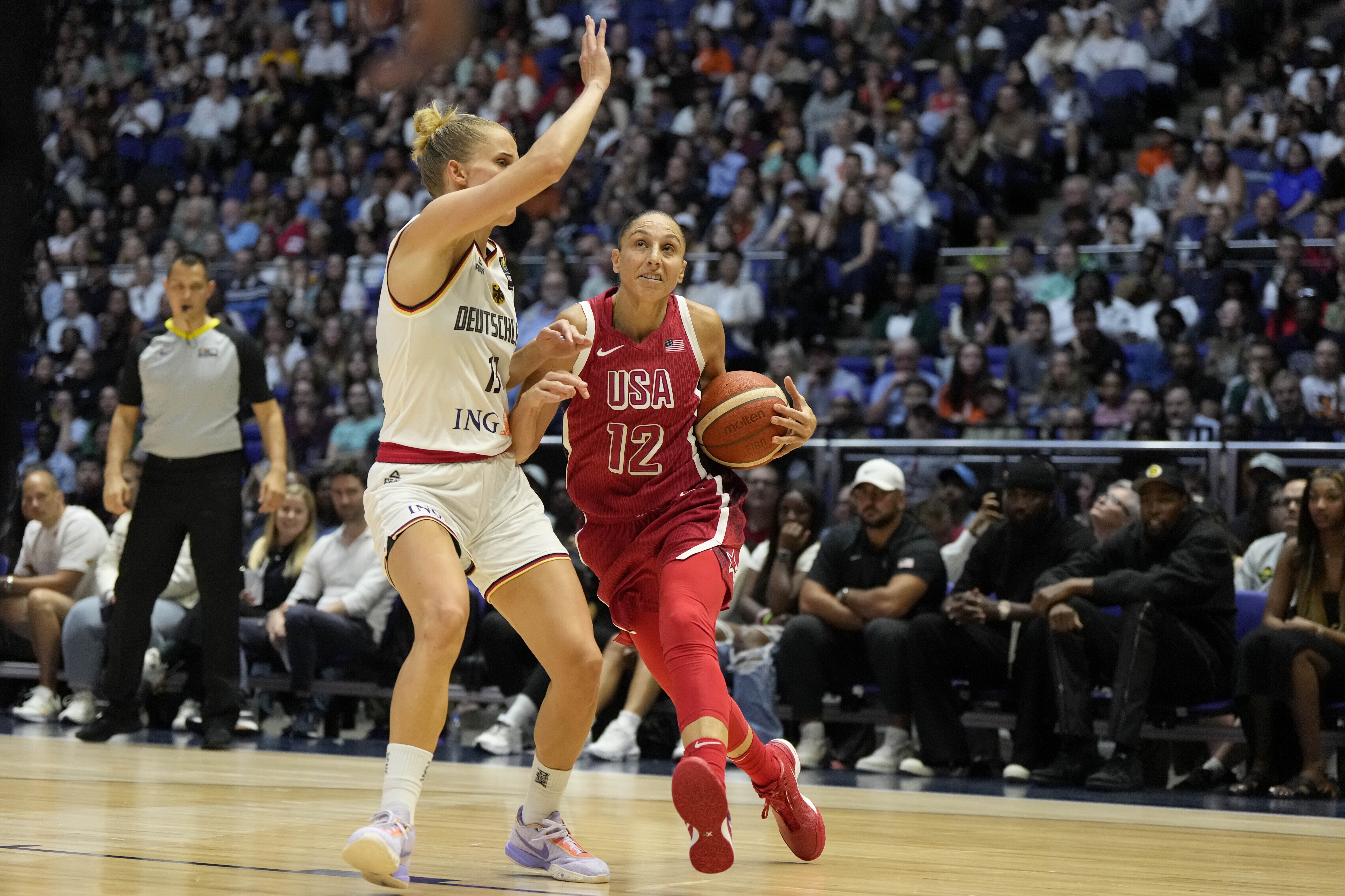 United States' Diana Taurasi (right) drives around Germany's Leonie Fiebich during a women's exhibition basketball game between the United States and Germany in London on July 23, 2024. (AP)