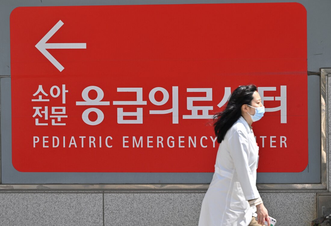 Een medische hulpverlener loopt op 1 april 2024 langs een bord voor een kindernoodcentrum buiten een ziekenhuis in Seoul.