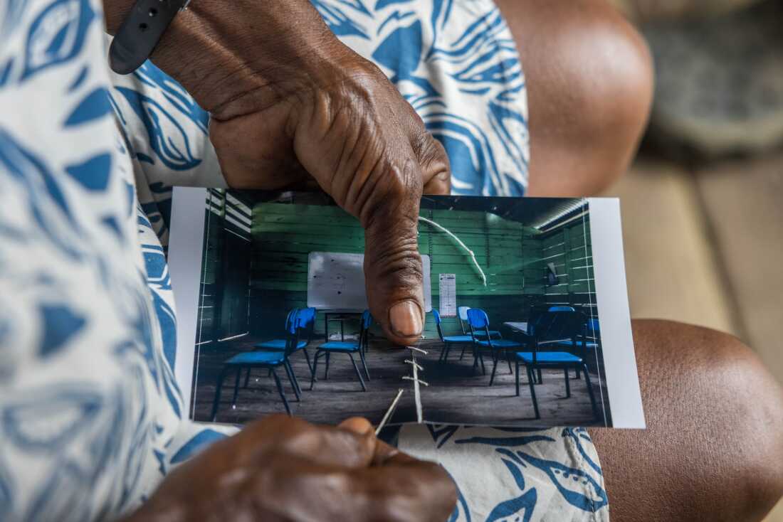 Margarita Rojas Mena, in Mojaudó, stitched up the photograph of the community school, wounded by bullets from an armed confrontation.