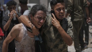 Palestinians react after carrying the bodies of those killed while trying to reach aid trucks entering northern Gaza through the Zikim crossing with Israel, at Shifa Hospital in Gaza City, Sunday.