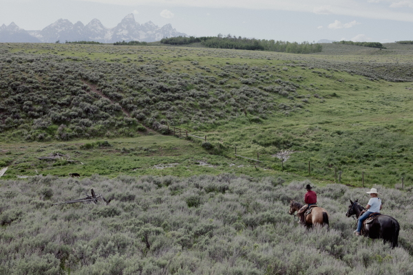 Jake Hutton and Anne McIntosh, a realtor visiting from Virginia, guide their horses past a spring on the Kelly Parcel.