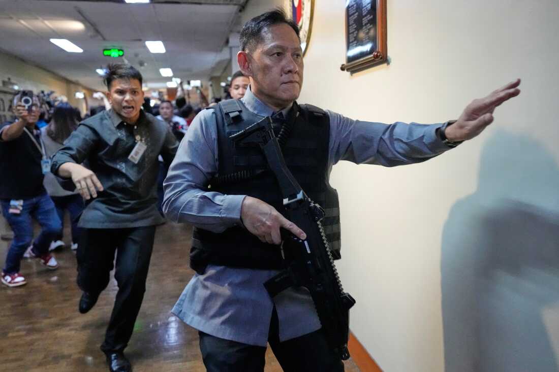 Senate security run after gunfire was heard along a hallway at the Philippine Senate in Pasay, Philippines, Wednesday.