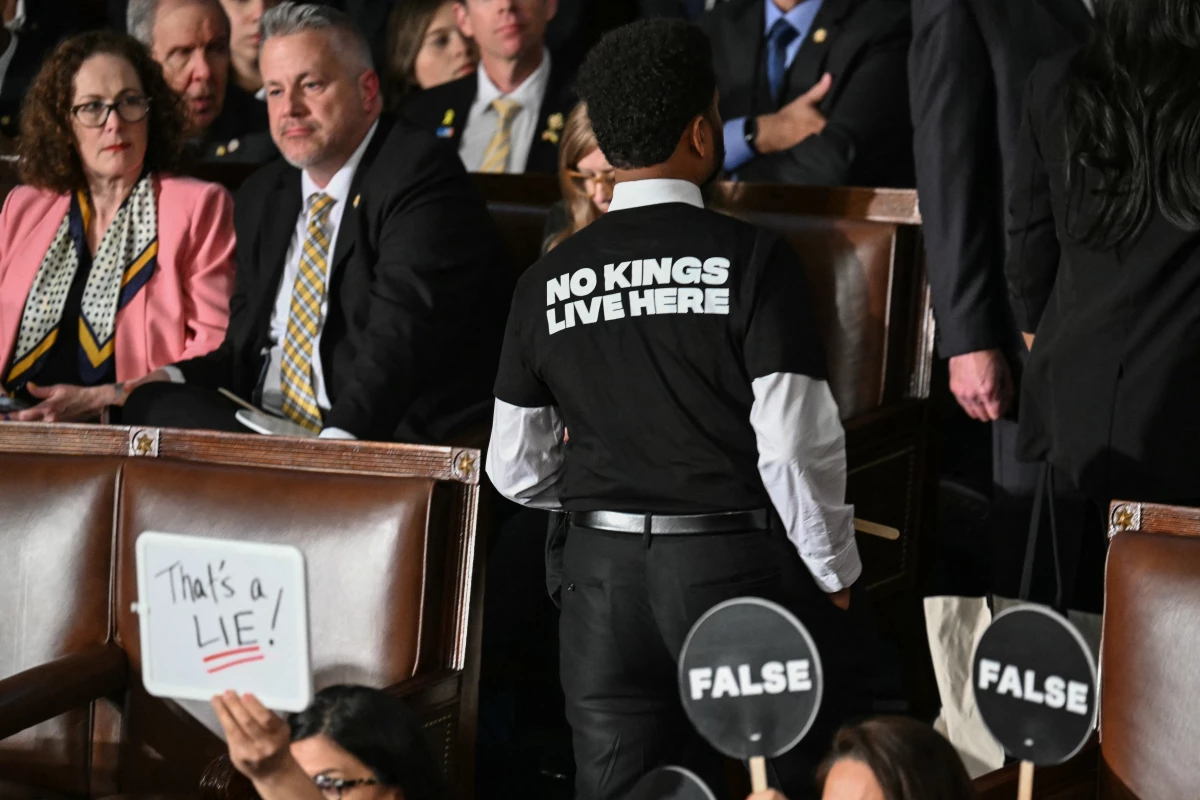 Representative Maxwell Frost, Democrat from Florida, wears a shirt reading 'No kings live here' as he walks out of the House Chamber while US President Donald Trump speaks during an address to a joint session of Congress.
