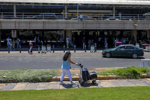 A passenger pushes a loaded trolley outside the departures' terminal at Rafic Hariri International Airport in Beirut on July 29.