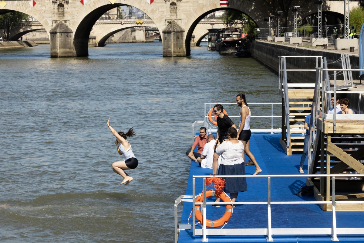 A local resident dives in the Seine, in Paris on July 17 after the mayor of Paris swim in the river to demonstrate that it is clean enough to host the outdoor swimming events at the Paris Olympics later this month.