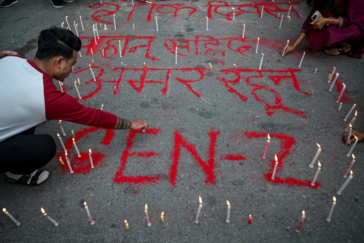 People light candles beside the words reading 'Long live martyrs' during a silent tribute observing a national day of mourning in honor of those killed in clashes during recent protests, in Kathmandu, Nepal, on Wednesday.