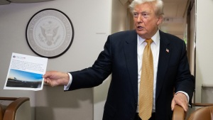 President Donald Trump holds up a copy of his Truth Social post about Air Force One as he speaks with the media aboard Air Force One on July 8, 2026. The president’s media company is offering investors early access to his Truth Social feed for up to $100,000 a month, raising ethical and legal concerns.