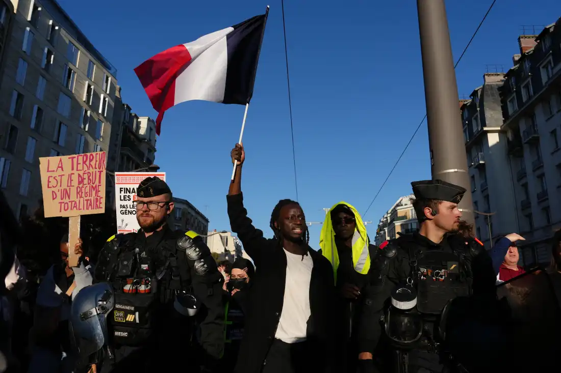 A demonstrator holds a French flag during a demonstration against rising living costs in Paris on Saturday.