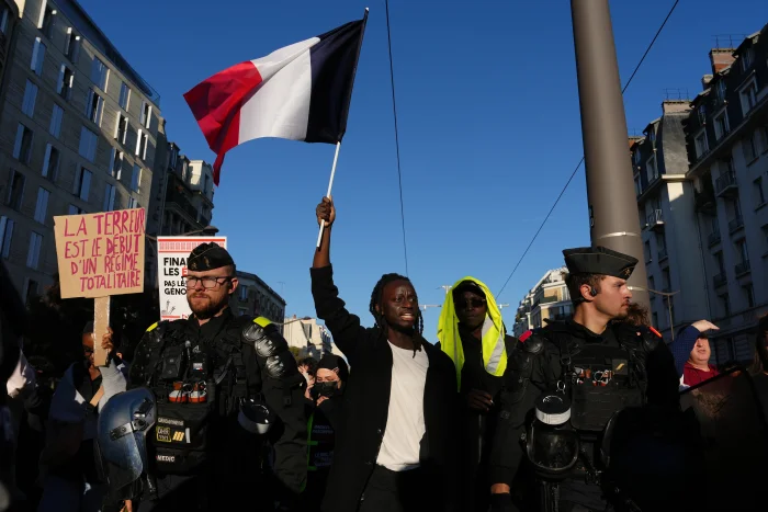 A demonstrator holds a French flag during a demonstration against rising living costs in Paris on Saturday.
