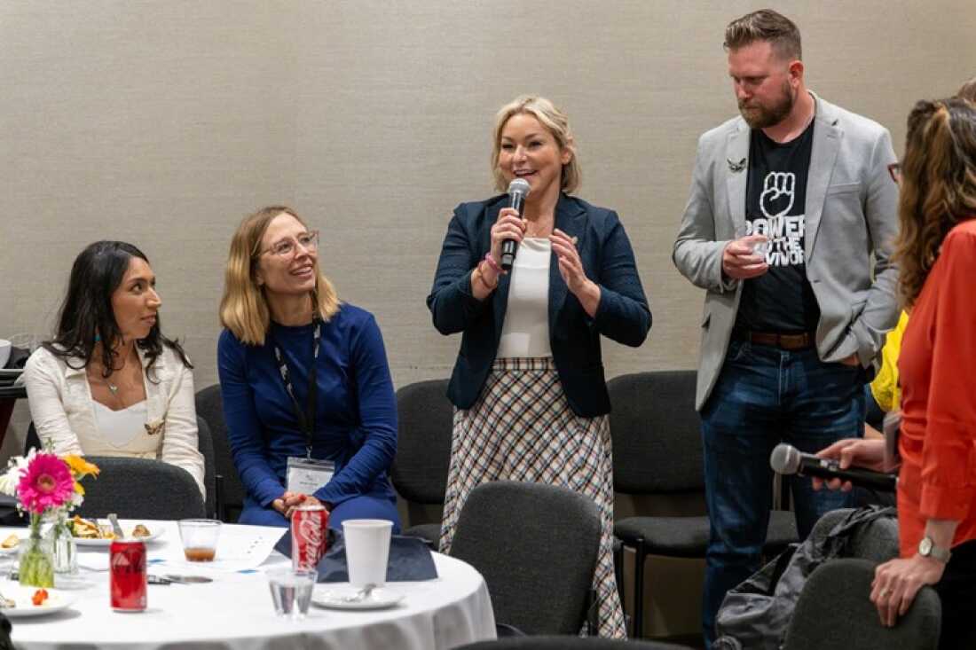 Dani Bensky, right, speaks at the World Without Exploitation conference in June while Annie Farmer, left, looks on.