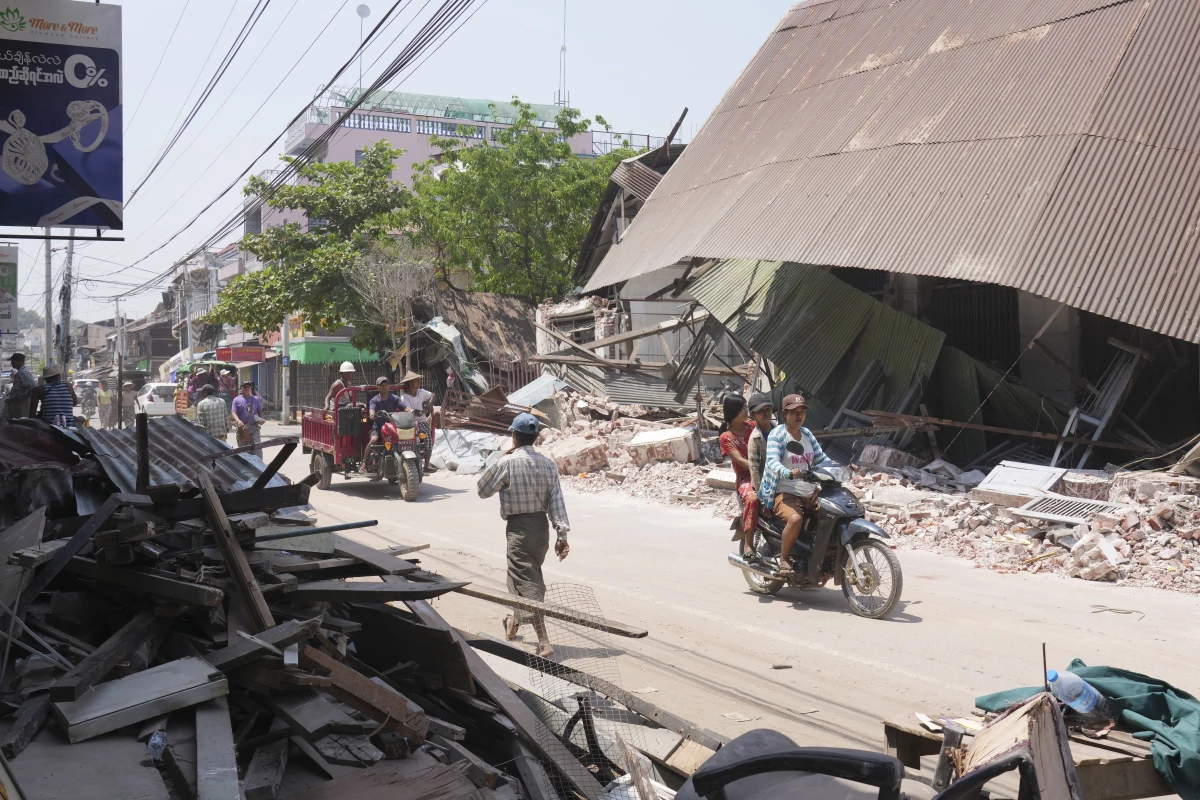 Local residents ride motorbikes near damaged buildings in the aftermath of Friday's earthquake, in Naypyitaw, Myanmar on Wednesday.