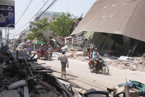 Local residents ride motorbikes near damaged buildings in the aftermath of Friday's earthquake, in Naypyitaw, Myanmar on Wednesday.