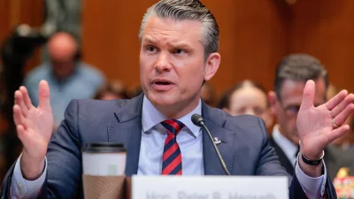 Defense Secretary Pete Hegseth memberikan kesaksian sebelum Komite Pengalokasian Dana Senat. Dia mengenakan setelan abu-abu gelap dengan dasi hitam-dan-merah.