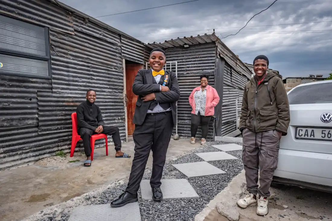 Aspiring magician Lubelo Mthenjana photographed with his family outside their home in the Khayelitsha neighbourhood of Cape Town, South Africa.