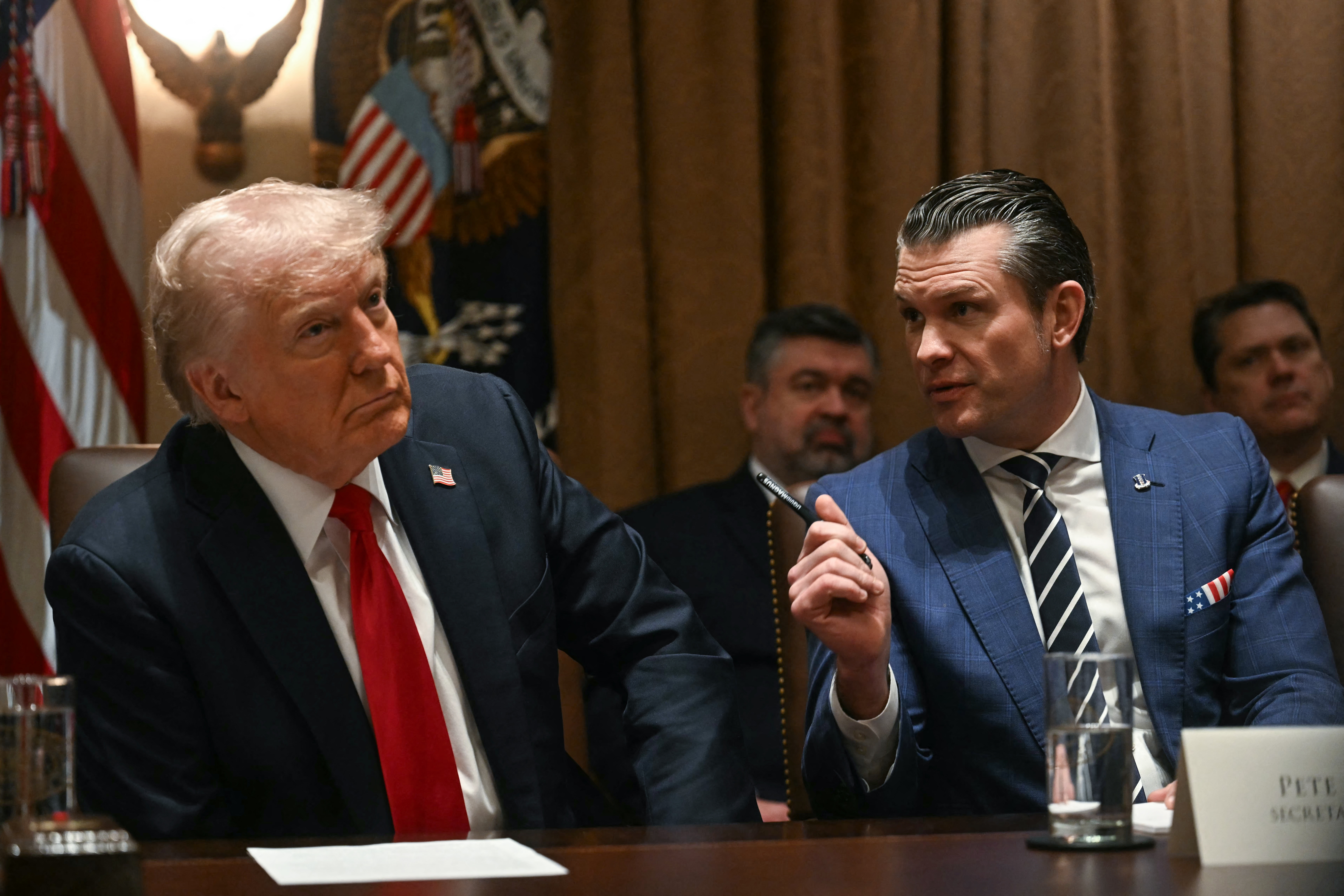 President Trump looks on as Defense Secretary Pete Hegseth speaks during a cabinet meeting at the White House on Wednesday. (AFP via Getty Images)