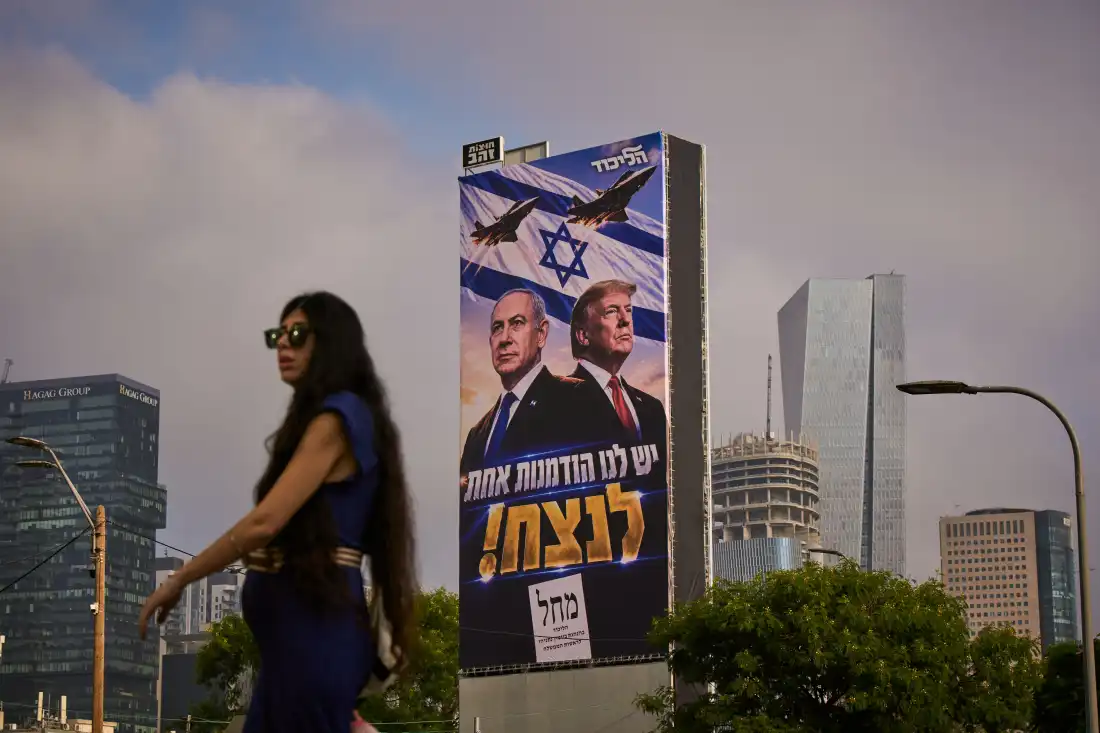 A woman walks past a Likud Party campaign billboard featuring President Trump and Israeli Prime Minister Benjamin Netanyahu, with a Hebrew message reading, "We have one opportunity to win," in Tel Aviv, Israel, on Monday.