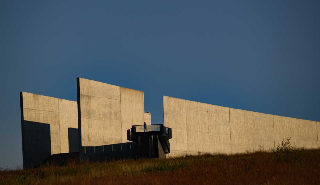A visitor stands at an outdoor lookout point at the Flight 93 National Memorial in Shanksville, Pennsylvania, on September 11, 2025. Behind the person are two parallel walls that form a portal.