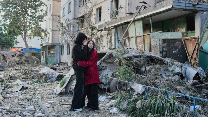 People react as they look at the site of a Russian missile strike that hit a residential building in Kyiv, Ukraine, Tuesday, June 2, 2026.