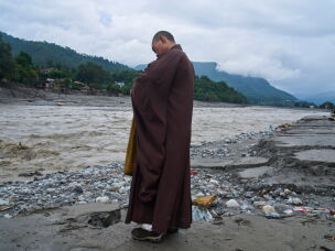 A Buddhist monk offers prayers for the departed soul of the victims of flash flood on the bank of Trishuli river in Devighat, Nuwakot district, Nepal, Saturday, Sept. 5, 2026.