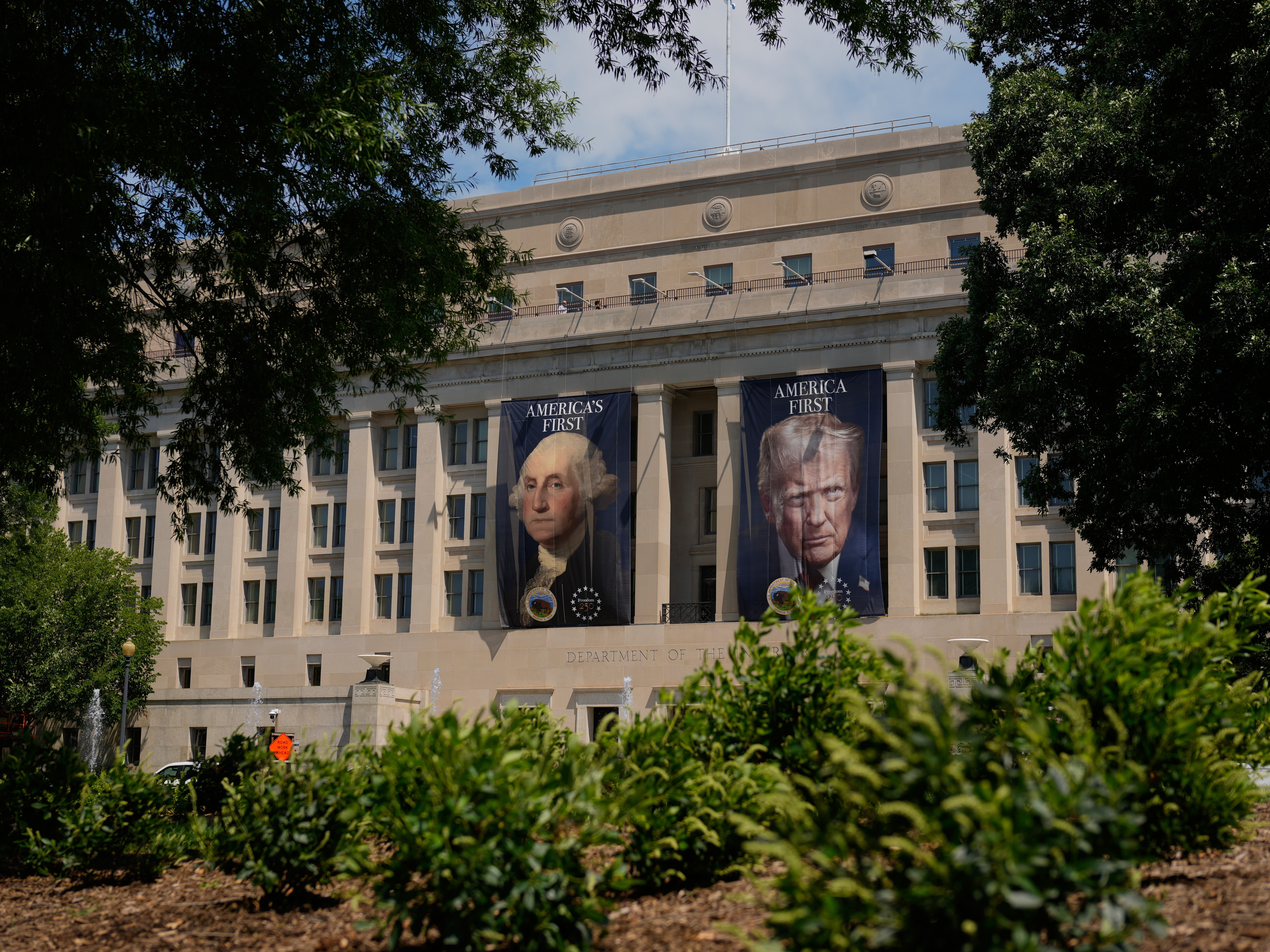 Banners of former President George Washington and President Donald Trump hang above an entrance to the Department of the Interior, Thursday, June 25, 2026, in Washington. Trump administration rolls back a key protection for imperiled wildlife
