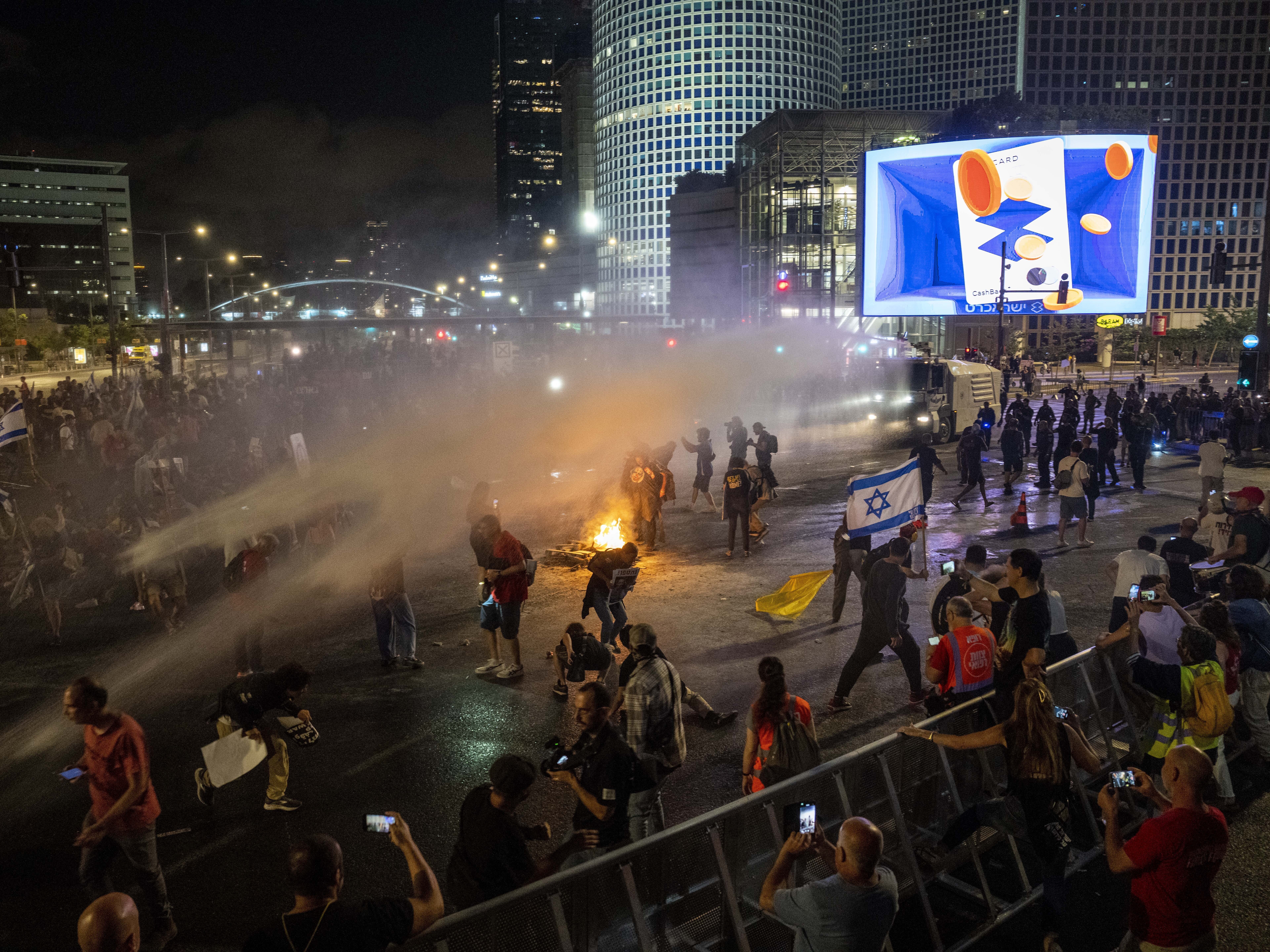 Police use water cannon to disperse demonstrators during a protest against Israeli Prime Minister Benjamin Netanyahu