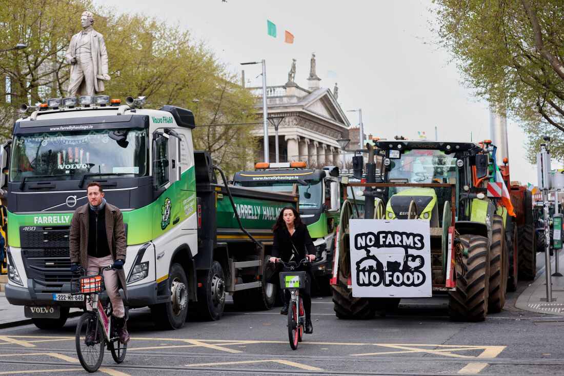 Cyclists ride past tractors blocking O'Connell Street on the fifth day of the National Fuel Protest, in Dublin, Ireland, on Saturday.