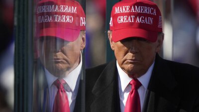 Former President Donald Trump is reflected in the bullet proof glass as he finishes speaking at a campaign rally in Lititz, Pa., on Nov. 3.
