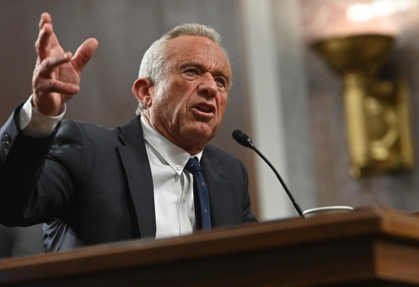 Robert F. Kennedy Jr. is shown gesturing in front of a microphone.