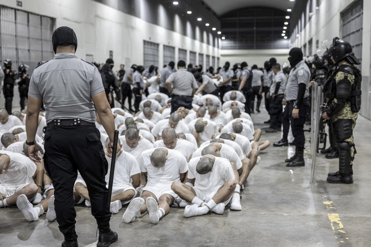 In this photo provided by El Salvador's presidential press office, a prison guard transfers deportees from the U.S., alleged to be Venezuelan gang members, to the Terrorism Confinement Center in Tecoluca, El Salvador, March 16, 2025.