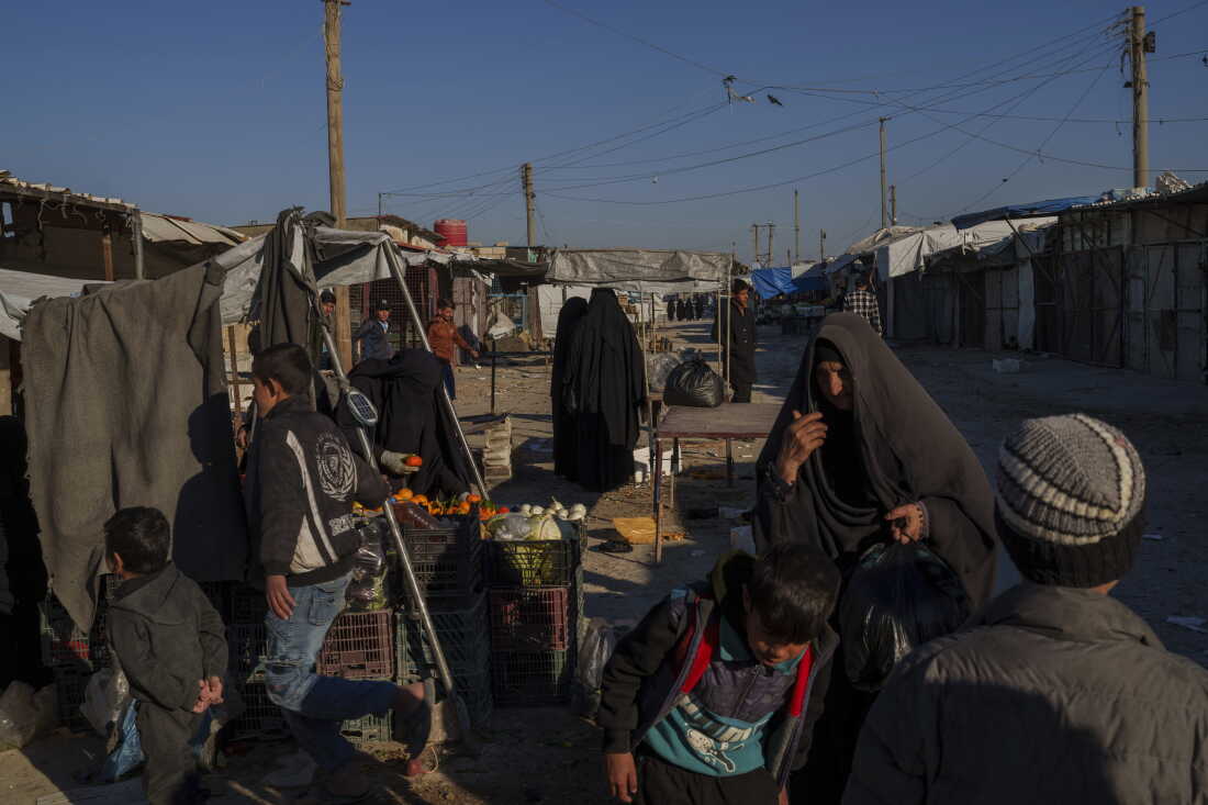 People stroll through the marketplace in the al-Hol detention camp on Jan. 30, 2025 in northeastern Syria's Hassakeh province, where tens of thousands of mostly women and children linked to the Islamic State group have been living for years.