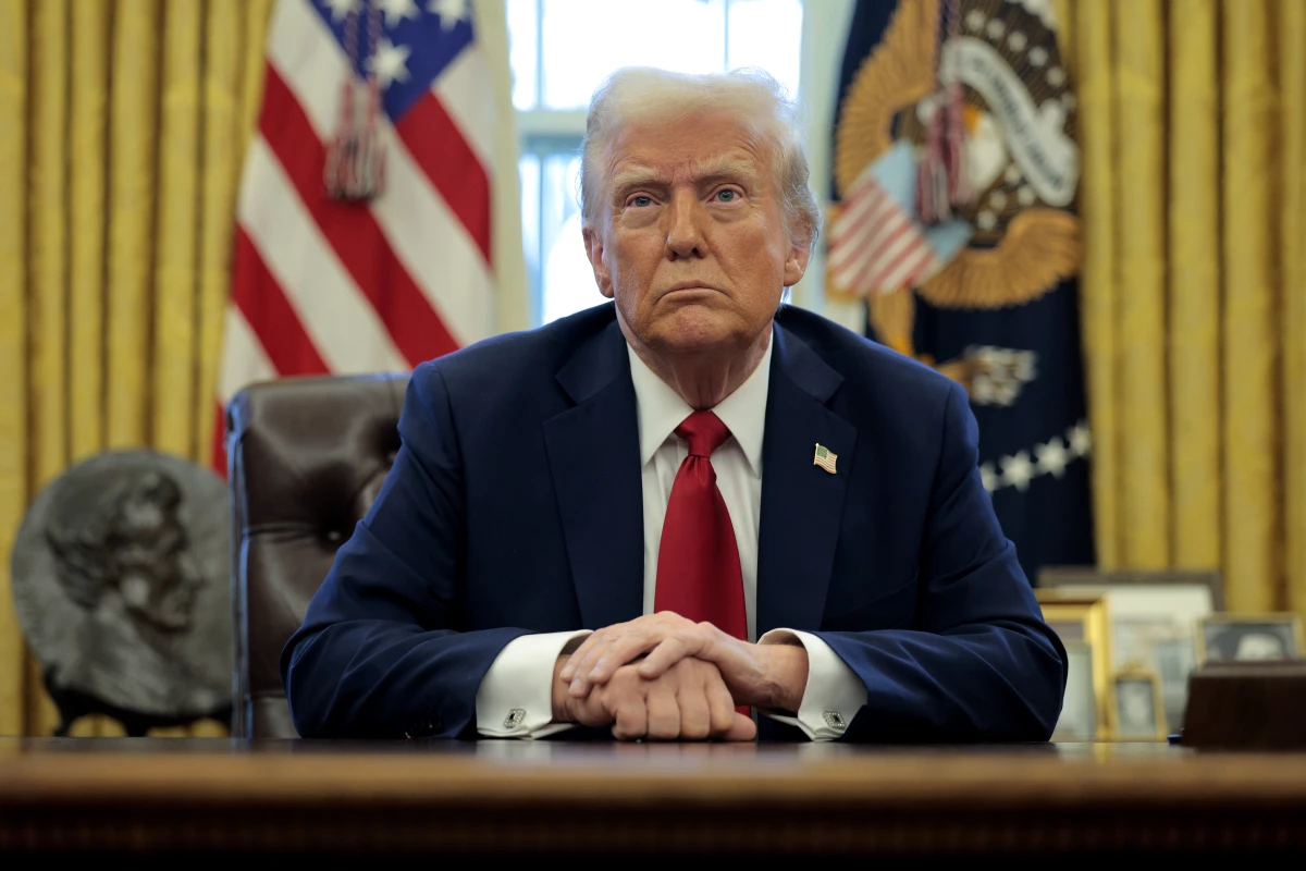 President Trump talks to reporters from the Resolute Desk on Jan. 30.