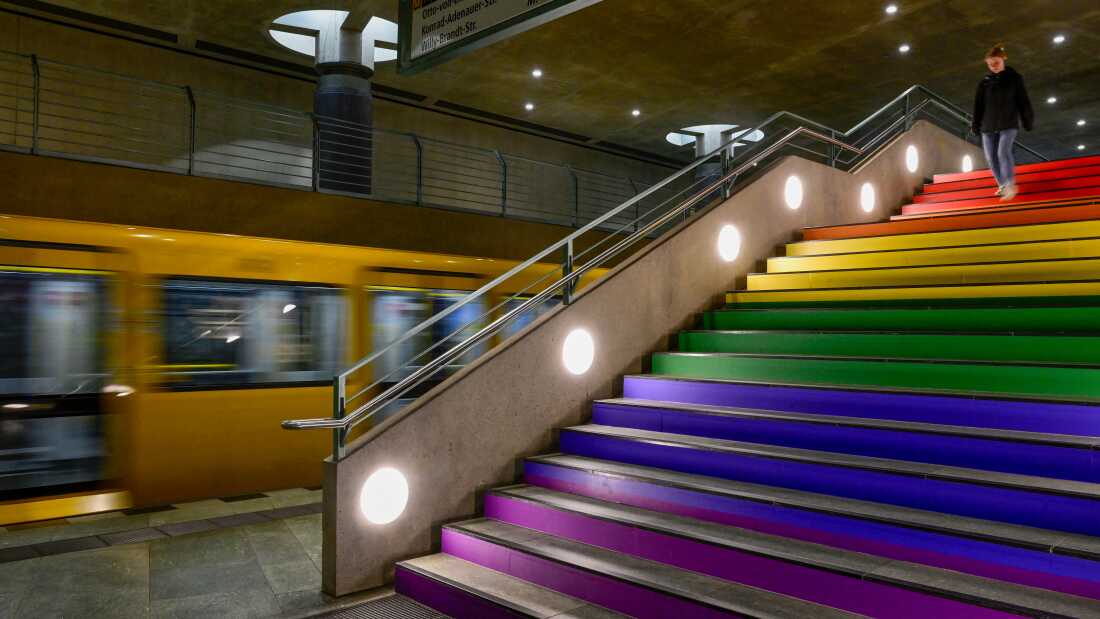A commuter walks down the steps of Berlin's Bundestag subway station, decorated with rainbow colors, the symbol of the LGBTQ+ community, on July 24.