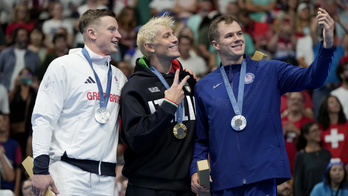 Adam Peaty, left, of Great Britain, tested positive for COVID on Monday, a day after he stood with Gold medalist Nicolo Martinenghi, center, of Italy, and dual silver medalist Nic Fink, of the United States. The men competed in the 100-meter breaststroke final at the 2024 Paris Olympics in Nanterre, France.