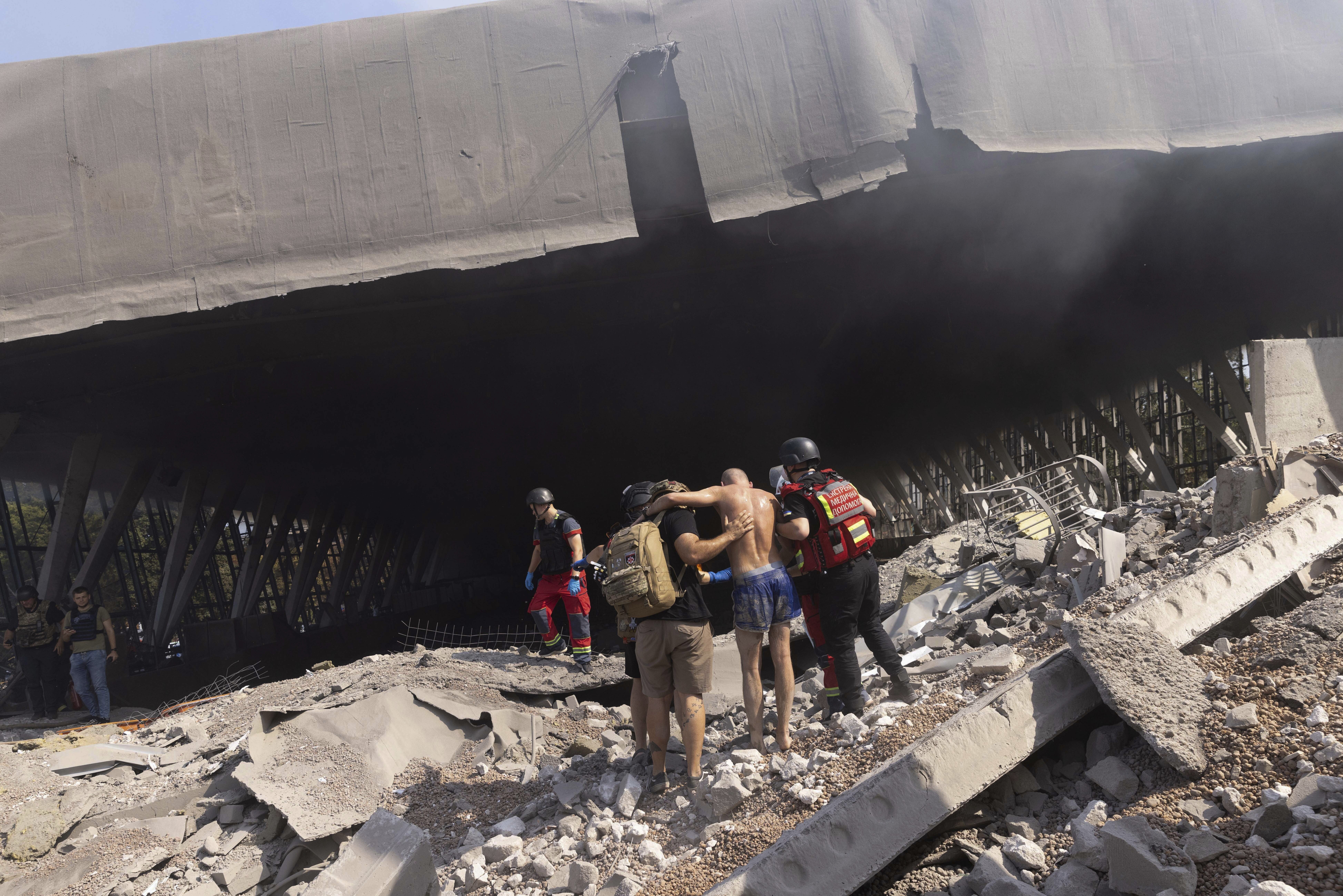 Paramedics help an injured man to walk out of the rubble at a sports facility destroyed after a Russian attack in Kharkiv, Ukraine, Sunday, Sept. 1 2024.