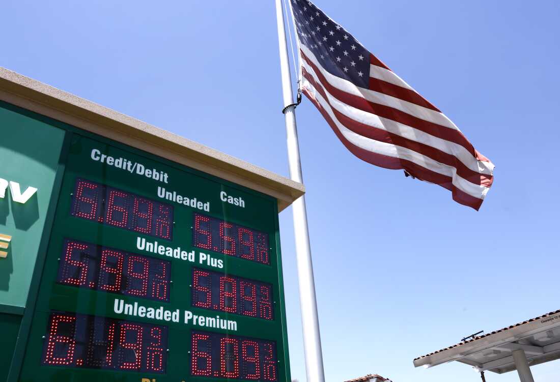 An American flag on a tall flagpole flies above a sign displaying gas prices in red digital numbers at a gas station in Arcadia, California, on May 11.