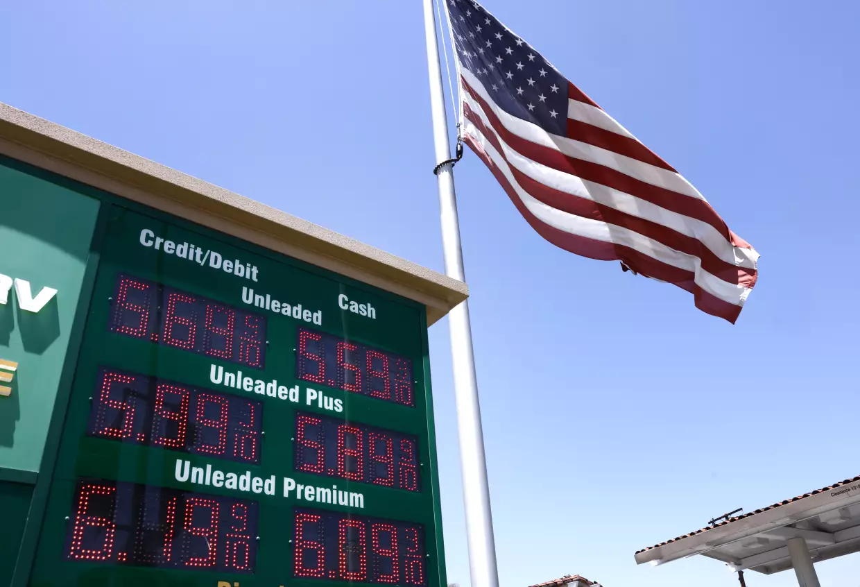 An American flag flies above a sign displaying gas prices at a gas station in Arcadia, Calif., on May 11.