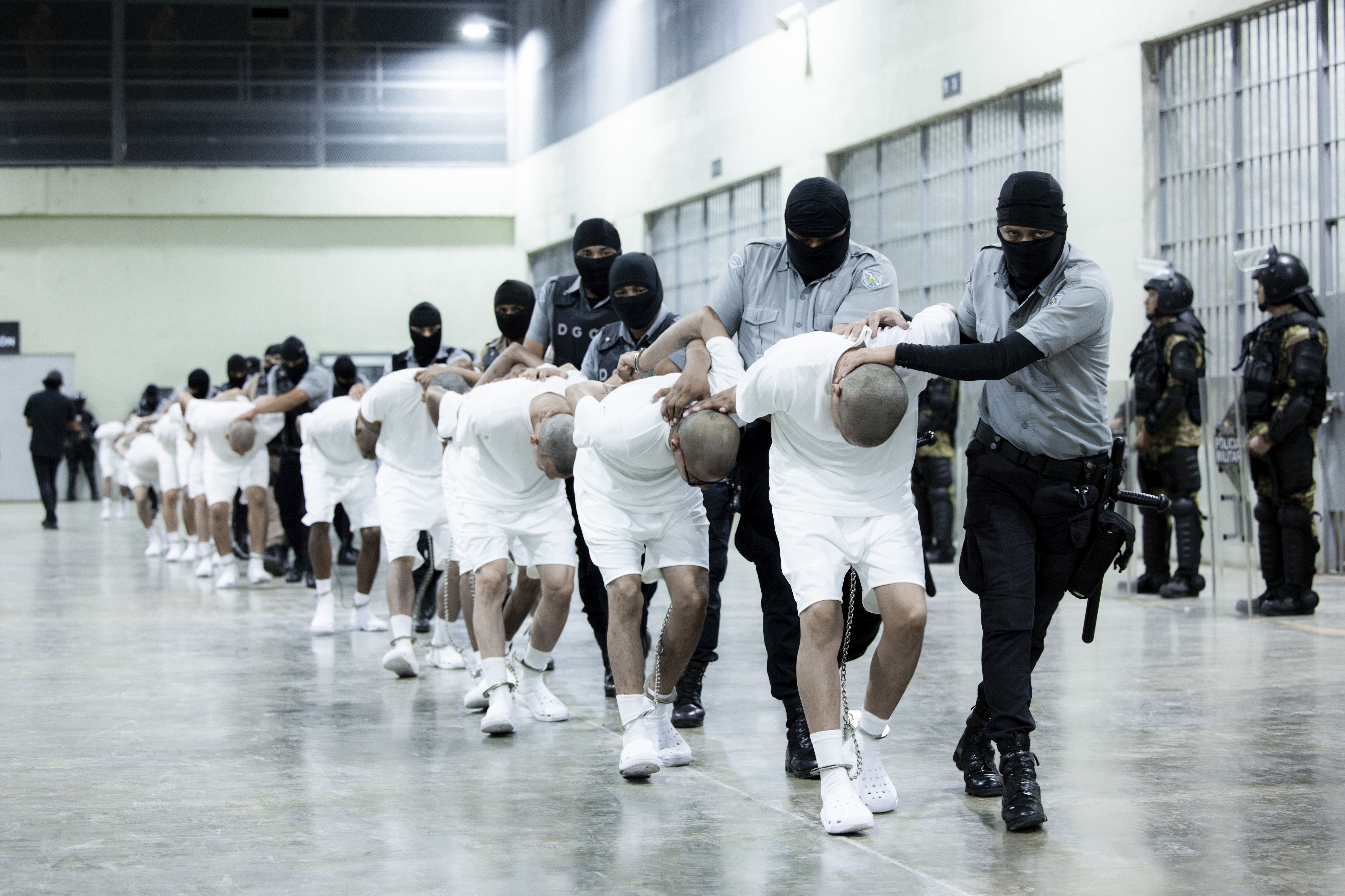In this photo provided by El Salvador's presidential press office, prison guards transfer deportees from the U.S., alleged to be Venezuelan gang members, to the Terrorism Confinement Center in Tecoluca, El Salvador, Sunday, March 16, 2025. (El Salvador presidential press office)