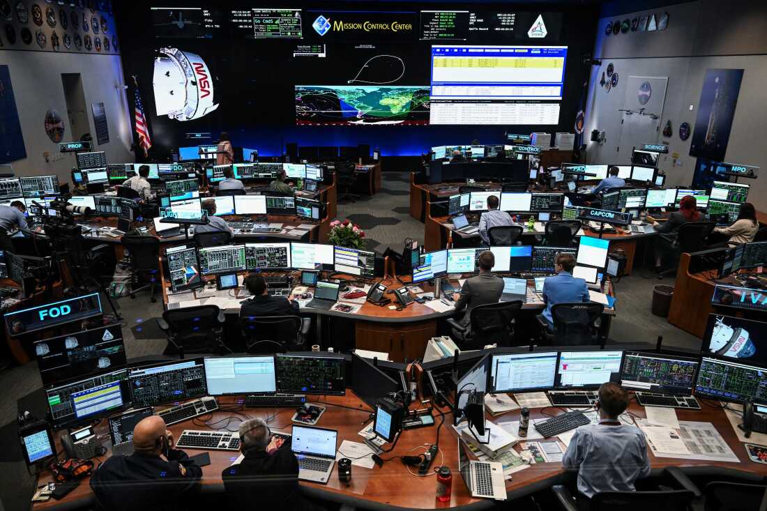 Artemis II controllers monitor the progress of the Orion spacecraft in the White Flight Control Room at Johnson Space Center in Houston, Texas, on April 3, 2026. Four Artemis astronauts were zooming towards the Moon late April 2 after a major engine firing, a milestone that commits NASA to the first crewed lunar flyby in more than half a century. With enough thrust to accelerate a stationary car to highway driving speed in less than three seconds, the Orion capsule engine blasted the astronauts on their trajectory towards the Moon, which they now will loop as part of the 10-day Artemis II mission. (Photo by RONALDO SCHEMIDT / AFP via Getty Images)