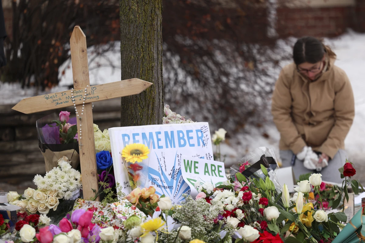 People gather at a makeshift memorial in Minneapolis for 37-year-old Renee Nicole Good, a day after she was fatally shot.