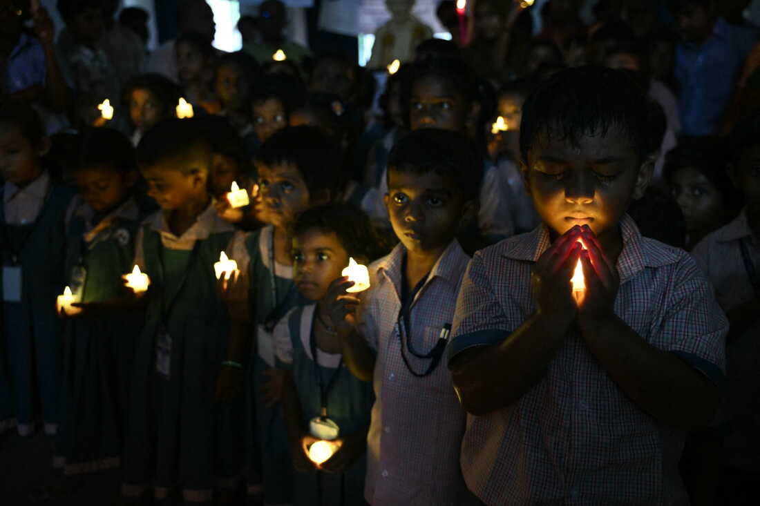 School students hold LED candles as they gather to pay their homage to people who died in Nepal's flash flood, in Chennai.